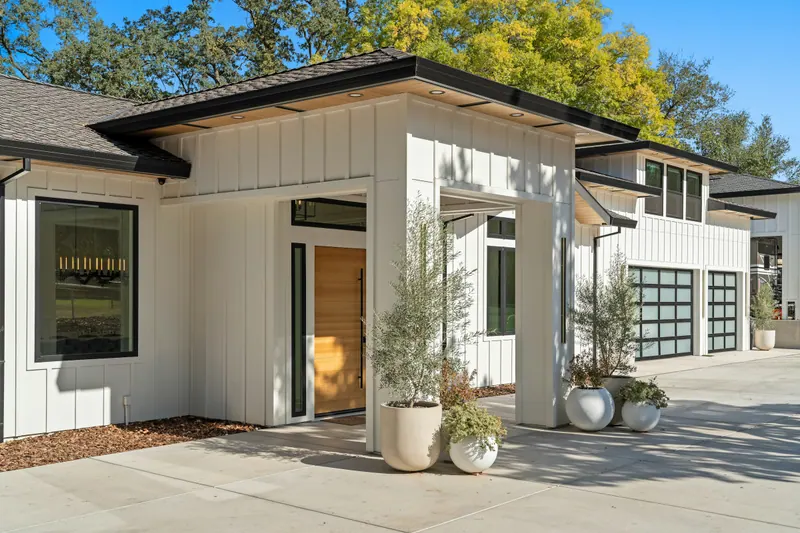 Modern Front Yard Design: A clean, welcoming arrival: a broad forecourt, statement planters and simple beds that suit the house.