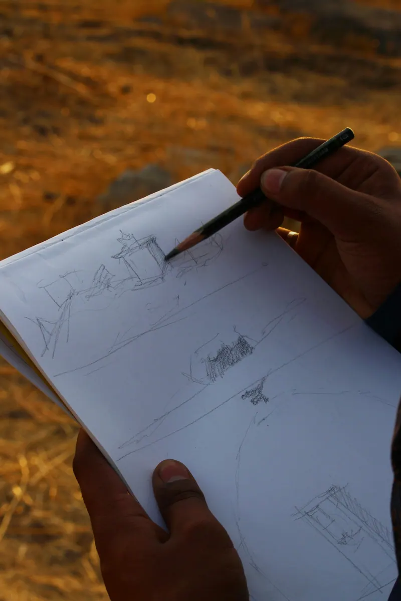 A designer sketching ideas in a notebook on site.